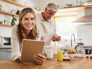 Customer using a tablet at home with Amherst Communications 300 Mbps Fiber Internet service
